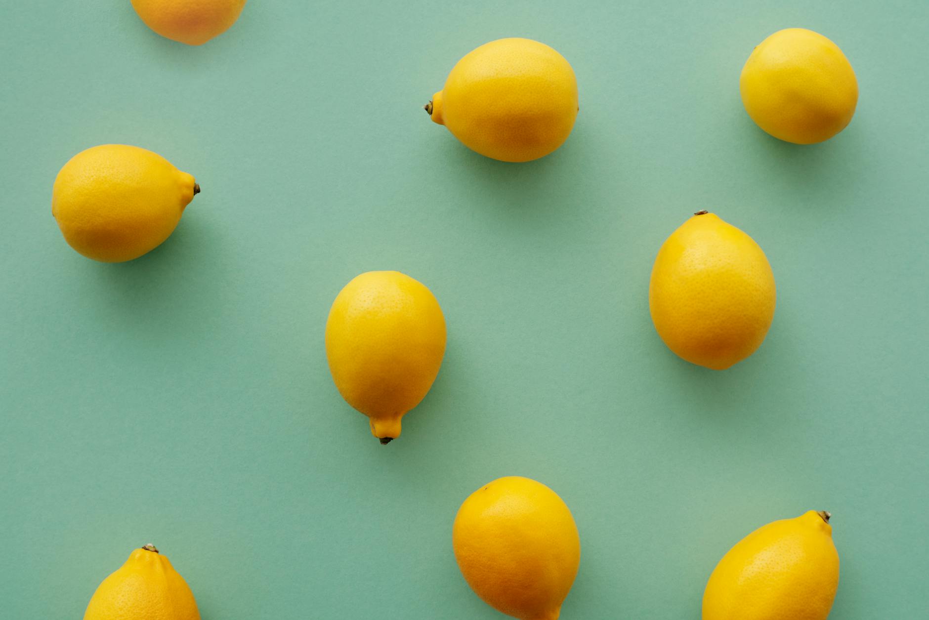 Bright yellow lemons arranged on a pastel green background, symbolizing fresh approaches to intimacy