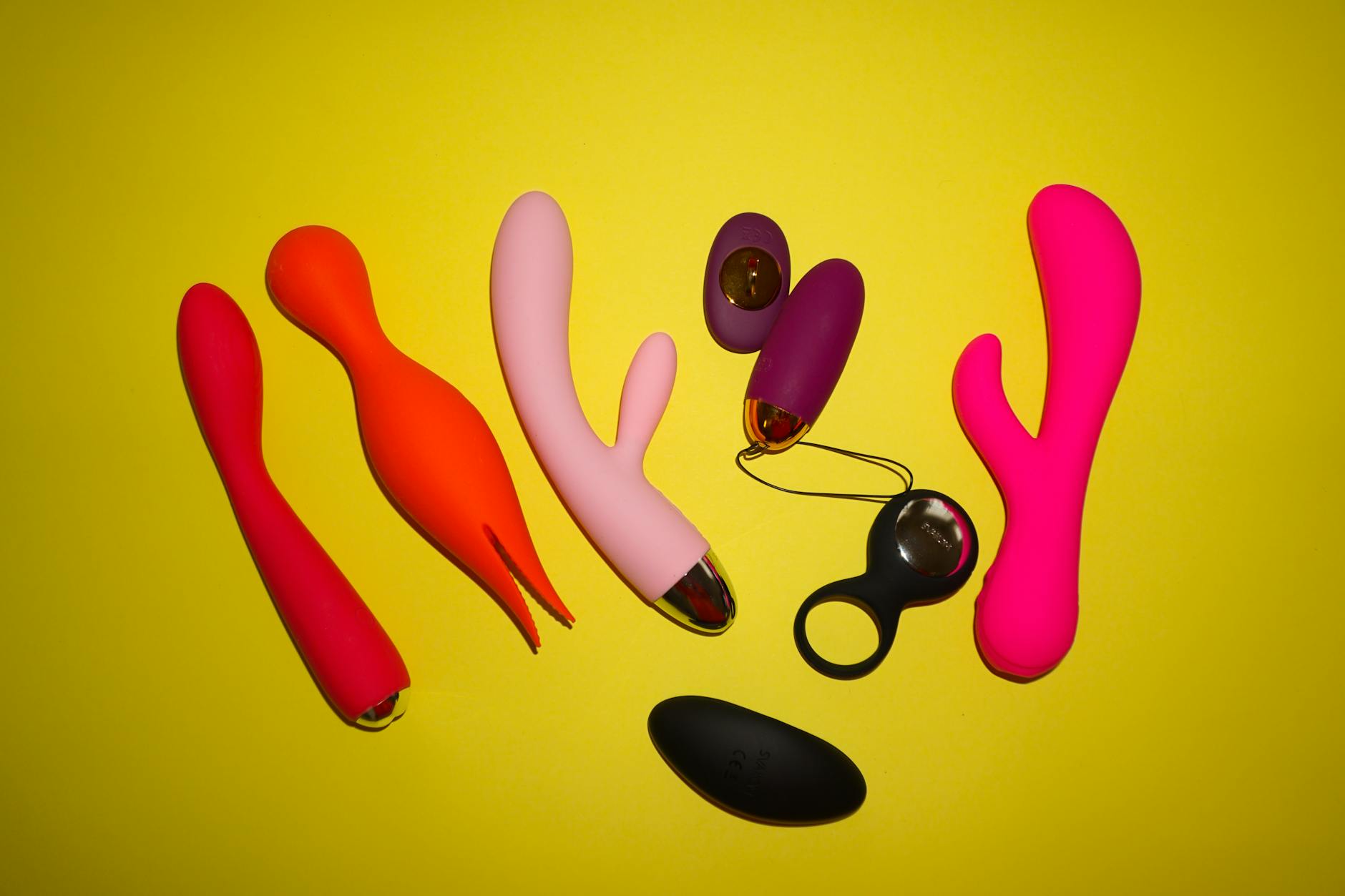 Close-up of hands holding a modern vibrator against a minimalist purple backdrop