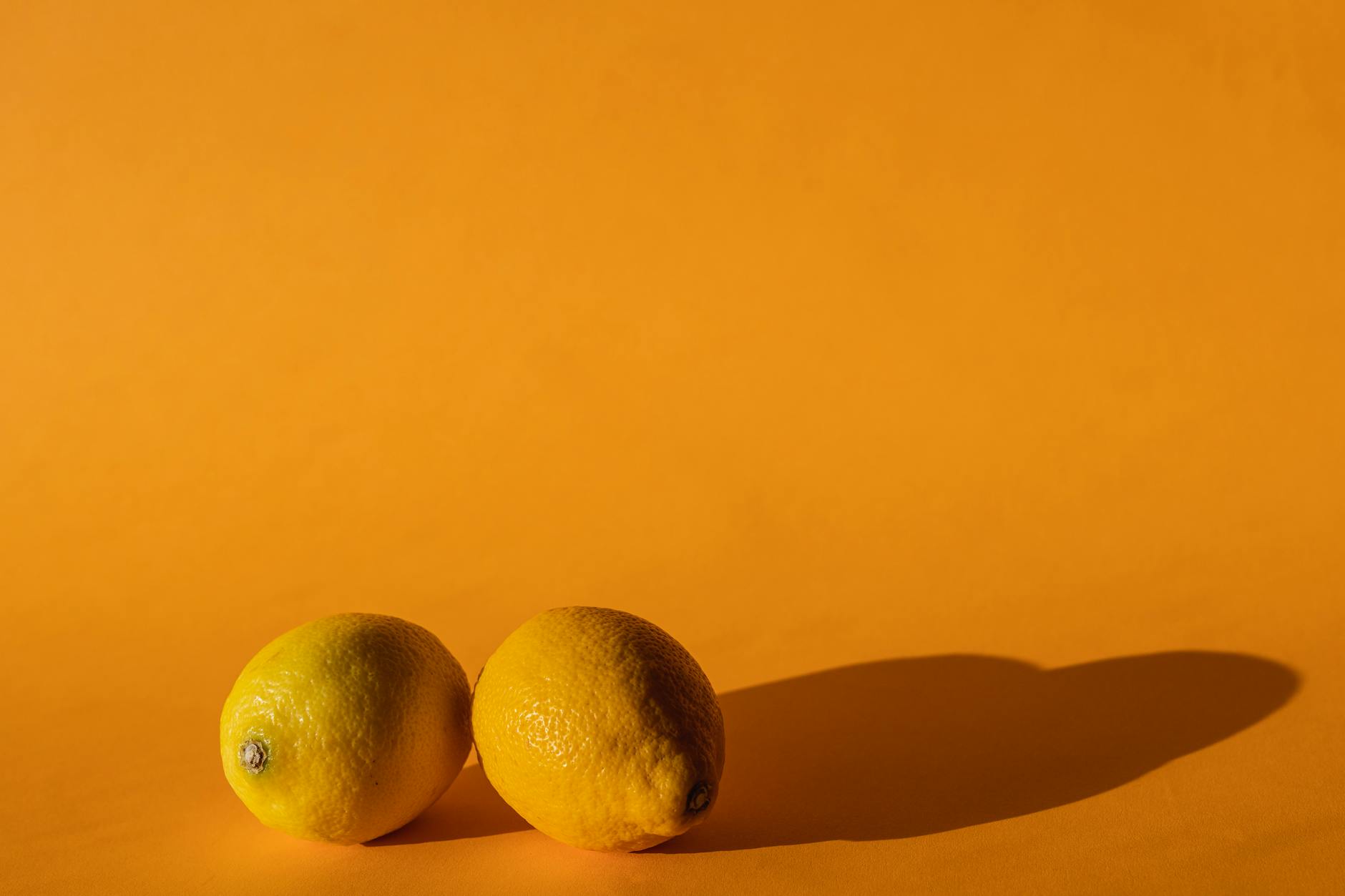 Vibrant lemons arranged on a bright yellow background, representing openness and fresh communication between partners